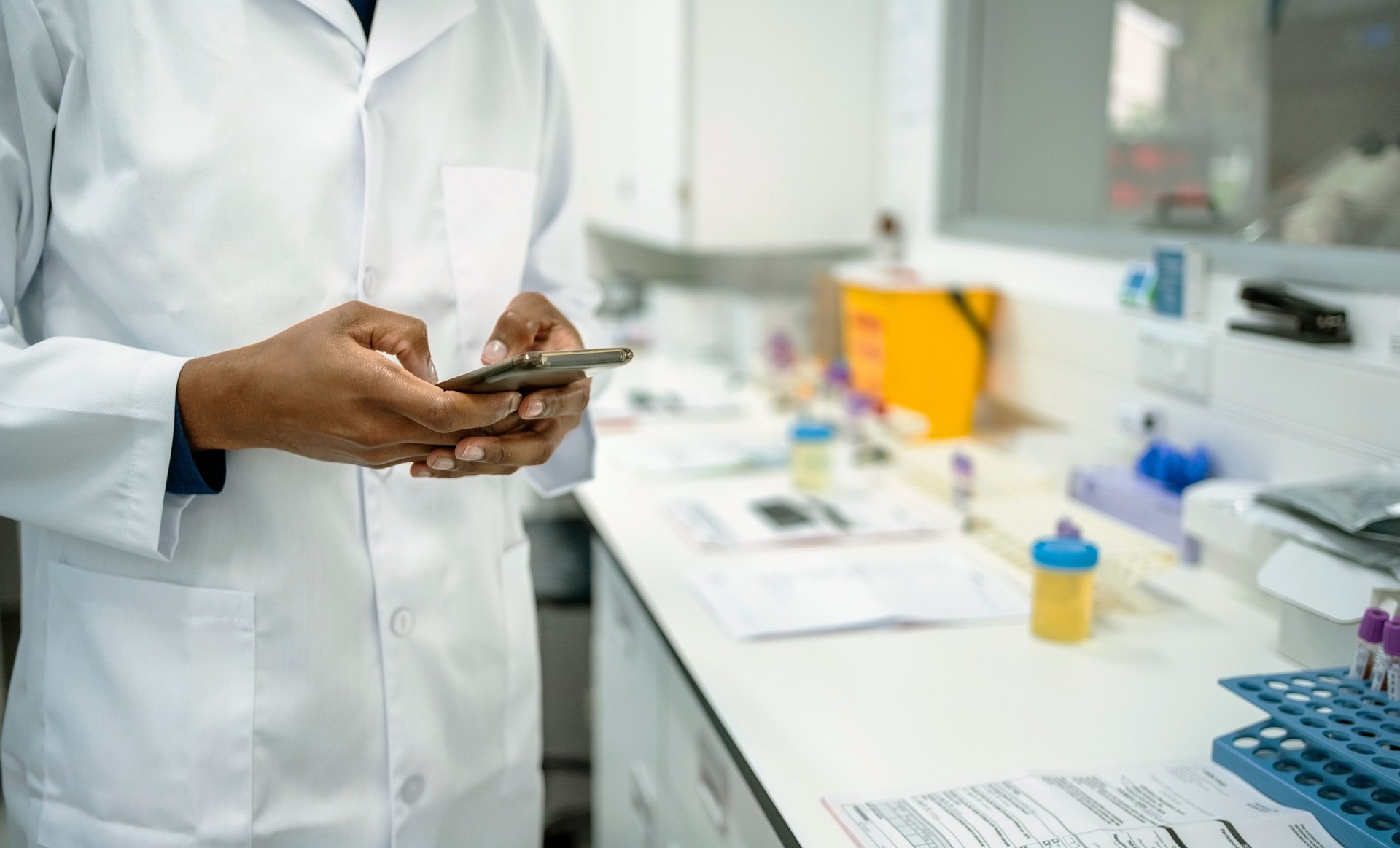 Close-up of a lab technician using mobile phone in a pathology lab